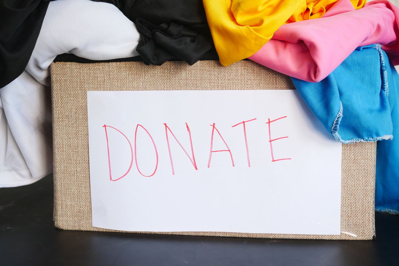 A donation box filled with colourful clothing, symbolising charity and community support.