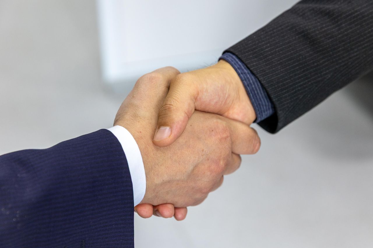 Close-up of two businessmen shaking hands, symbolising agreement and partnership.